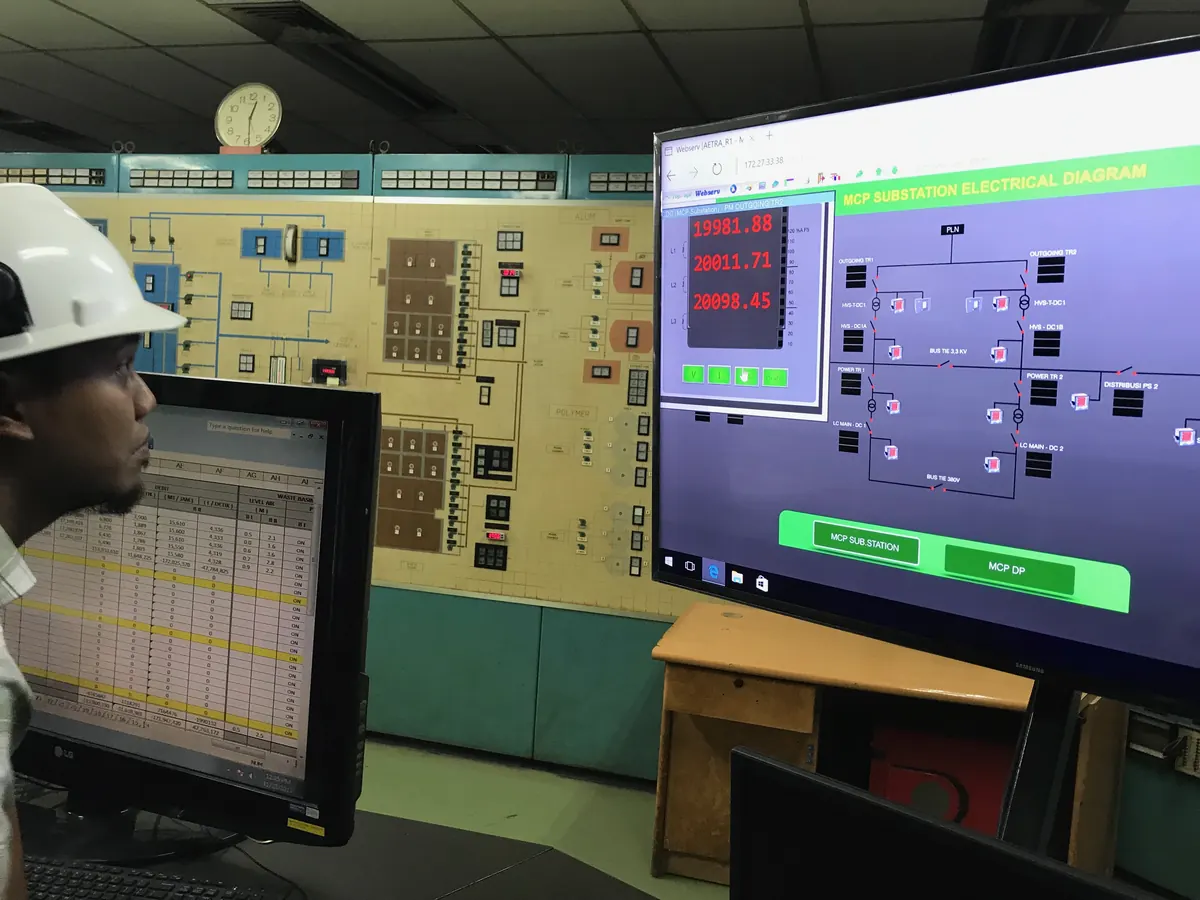 Engineer reviewing a substation SCADA screen in an MCC room
